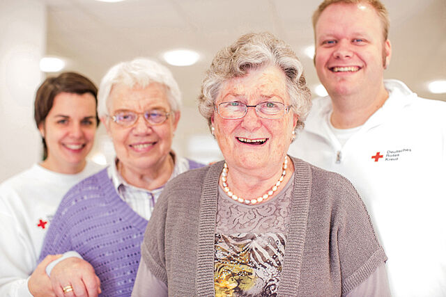 Gemeinsames Foto der Pflegekräfte und Bewohnern. Szene DRK - Ambulante Wohngemeinschaften.