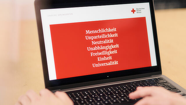 Darstellung Grundsätze der Rotkreuz- und Rothalbmond-Bewegung auf dem Bildschirm eines Laptops